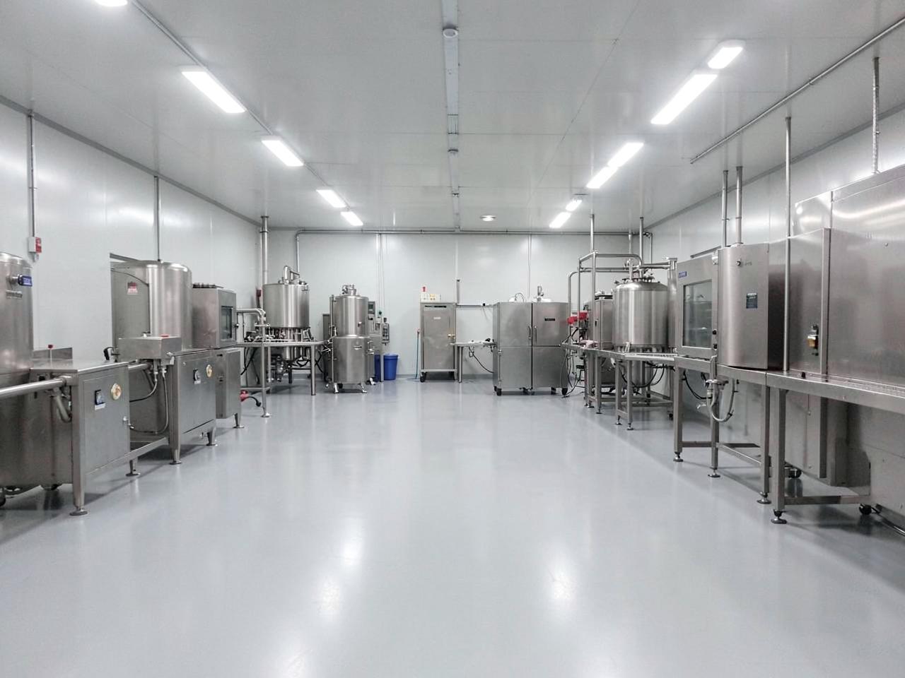 Khu vực chế biến thực phẩm với sàn phủ liền mạch màu xám nhạt và thiết bị inox